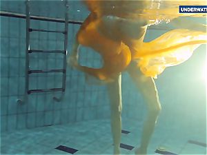 Yellow and red dressed nubile underwater